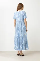 Maxi vestido celeste con estampado de hojas blancas y azules, de corte suelto y manga corta.