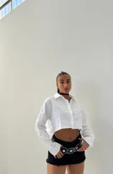 Camisa blanca de mangas largas, corte crop y cuello clásico.