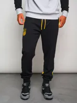 Pantalón de jogging negro con cordones amarillos, puños ajustados y escudo del Club Atlético Peñarol bordado en amarillo.