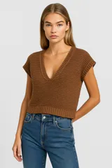 Musculosa color crema de acrílico con punto canalé, corte holgado y escote en V profundo.