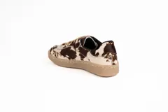 Zapatillas bajas con capellada de pelo de vaca color marrón y blanco, con cordones finos color beige y suela de goma color beige.