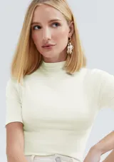 Camiseta verde claro de tela acanalada, con cuello alto y mangas cortas.