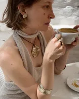 Collar con dije grande de bronce con forma de ostra y cordón de algodón ajustable color gris.