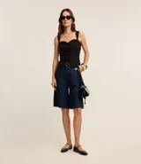 Blusa blanca de tejido plano en sastrería, con escote corazón, breteles anchos, botones forrados, elástico en la espalda y bajo con recorte V.