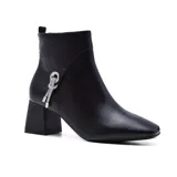 Botín negro de cuero sintético con punta fina y taco cuadrado. Presenta un aplique plateado con strass en el lateral.