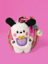 Llavero con mini peluche de perro blanco con orejas negras, babero lila y moño amarillo. Incluye correa de goma elástica en tonos rosa y celeste, dije de perla y mosquetón metálico rosa.