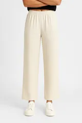 Pantalón beige holgado de algodón con cintura elástica.