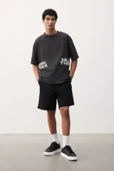 Short negro de lona de algodón, con cintura elástica ajustable con cordón, bolsillos laterales y bolsillo trasero.