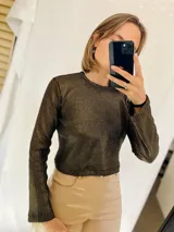 Sweater dorado de mangas largas con tejido brillante.