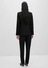 Pantalón de vestir negro de corte recto, con trabillas, bolsillos laterales y cierre oculto de botón, gancho y cremallera.