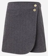 Minifalda gris de tweed con diseño cruzado, cierre lateral con cremallera oculta y dos botones dorados decorativos en la parte delantera.
