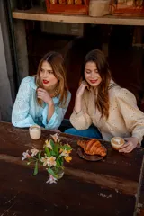Camisa color beige con bordado inglés, de corte recto, manga larga abullonada con puño y cuello camisero.