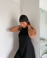 Vestido corto lila con cuello halter y espalda descubierta.