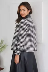Campera corta con estampado pata de gallo en blanco y negro, cuello y puños de cuero sintético negro, doble botonadura y corte holgado.