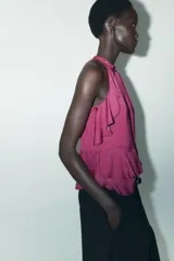 Top color fucsia de cuello halter con volantes en el mismo tejido. Cierre en la espalda con abertura y botones.