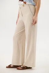 Pantalón de lino azul de corte palazzo con botón decorativo en la cintura.