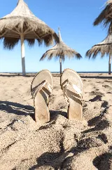 Sandalias tipo chancleta con suela de caucho flexible, acolchonadas y de cuero metalizado plateado.