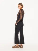 Pantalón negro de corte cropped y acampanado, confeccionado en tejido 4way.