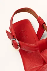 Sandalias franciscanas rojas de cuero con tiras entretejidas y hebilla lateral.