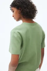 Remera verde de punto fino con cuello redondo y mangas cortas.