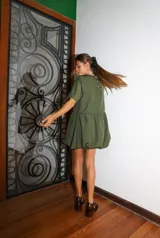 Vestido corto negro con corte en la cintura y falda balloon, de manga corta y cuello redondo.