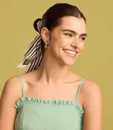 Vestido corto color verde agua, con breteles finos, escote recto con volados y falda con volado en el ruedo.