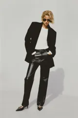 Pantalón de cuero sintético negro, de corte recto, tiro alto y cinco bolsillos.