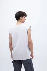 Musculosa gris con cuello redondo y estampado pequeño en el pecho. Corte clásico y sin mangas.