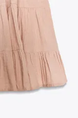 Vestido corto color salmón, de escote recto y tirantes finos ajustables. Presenta detalle de encaje en el escote y falda de tres niveles.