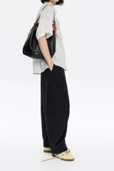 Bolso de mano negro marca Bimba y Lola, modelo Paper M, confeccionado en piel vacuna con estructura blanda. Incluye asa extraíble, bolsillo interior, etiqueta de tejido y logo metálico plateado.