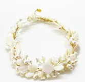 Collar corto hecho a mano con piezas de nácar blanco en forma de pétalos y perlas, engarzadas con hilo dorado. Cierre de mosquetón con cadena regulable.