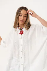 Camisa blanca con calados, escote en V, abotonada y manga 3/4.