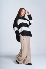 Sweater de punto con rayas horizontales anchas en blanco y negro. De corte amplio y relajado, brinda máxima comodidad sin perder el estilo. Su diseño atemporal lo convierte en una prenda versátil, ideal para combinar con jeans o pantalones para un look casual y abrigado en los días más frescos.