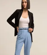 Pantalón de vestir rojo, estilo carrot (holgado en cadera y ajustado en tobillo), con pliegues frontales y cinturón de material sintético negro con hebilla pequeña.