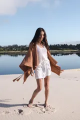 Saco tipo poncho color salmón, tejido en algodón, de silueta oversize y mangas 3/4 caídas.