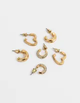 Set de tres pares de aros tipo argolla bañados en oro. Un par con incrustaciones de strass, un par con textura acanalada y un par liso.