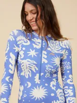 Rashguard Rusty de lycra estampada en tonos celeste y blanco, con cierre frontal y mangas largas.