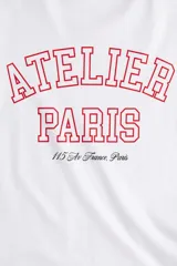 Remera blanca de algodón con estampado rojo que dice "Atelier Paris 115 Av. France, Paris".