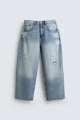 Pantalón de jean celeste con lavado gastado, corte holgado y roturas en ambas piernas.