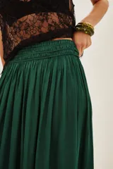 Falda larga de corte fluido en color azul petróleo, con cintura ancha elástica tipo smock y un volado amplio en el ruedo.