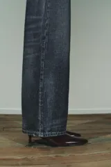 Botín color bordó con efecto acharolado, caña baja, tacón kitten de 4 cm y punta fina. Cierre mediante cremallera lateral.