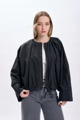 Campera negra corta con frunces en la cintura y cierre frontal.