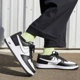 Zapatillas Nike Air Force 1 07 blancas con detalles en rojo, incluyendo el logo Swoosh, la suela y el logo "Air" en el lateral.