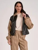 Campera bomber de cuero sintético negra con mangas color beige, cuello clásico y cierre frontal con cremallera.