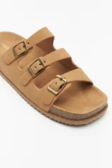 Sandalias negras con base de corcho y triple tira ajustable de gamuza con hebillas metálicas.