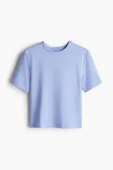 Top deportivo corto de color celeste, confeccionado en tejido funcional DryMove™ que ayuda a absorber el sudor. Tiene cuello redondo, mangas cortas y corte ajustado.