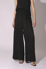 Conjunto de pantalón y top de seda color gris, con cuello halter y corte holgado.