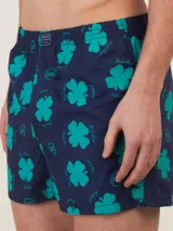Bóxer de algodón con estampado floral en tonos azul y blanco, con cintura elástica y logo de la marca en el centro.