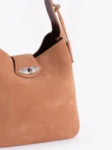 Cartera tipo hobo color marrón oscuro con efecto gastado, confeccionada en cuero vacuno. Tiene un asa de hombro, cierre de torniquete metálico y un sobre interno extraíble.