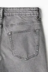 Jean gris de cinco bolsillos en denim de algodón elástico con cintura estándar y cierre con botón. Piernas rectas con buena libertad de movimiento en muslo y rodilla.